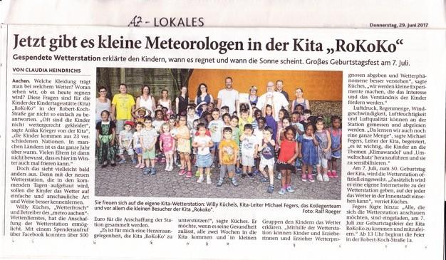 Foto von mehreren Kindern und Erwachsenen der Kita RoKoKo vor einem Gebäude. Einige halten bunte Wetter-Bastelarbeiten.