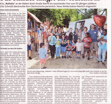 Foto von mehreren Erwachsenen und Kindern draußen vor einem Spielplatz mit bunten Ballons beim 50. Jubiläum eines Kindergartens.