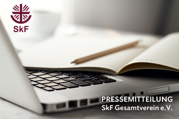 Foto von einer Laptop-Tastatur, darauf ein offenes Notizbuch mit Bleistift. Oben links das SkF-Logo und Text: PRESSEMITTEILUNG SkF Gesamtverein e.V.-aktuelle kirchliche Nachrichten wie aus einer Kirchenzeitung.